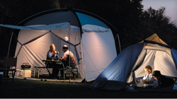 Portable generator powering lights and electronics at a campsite